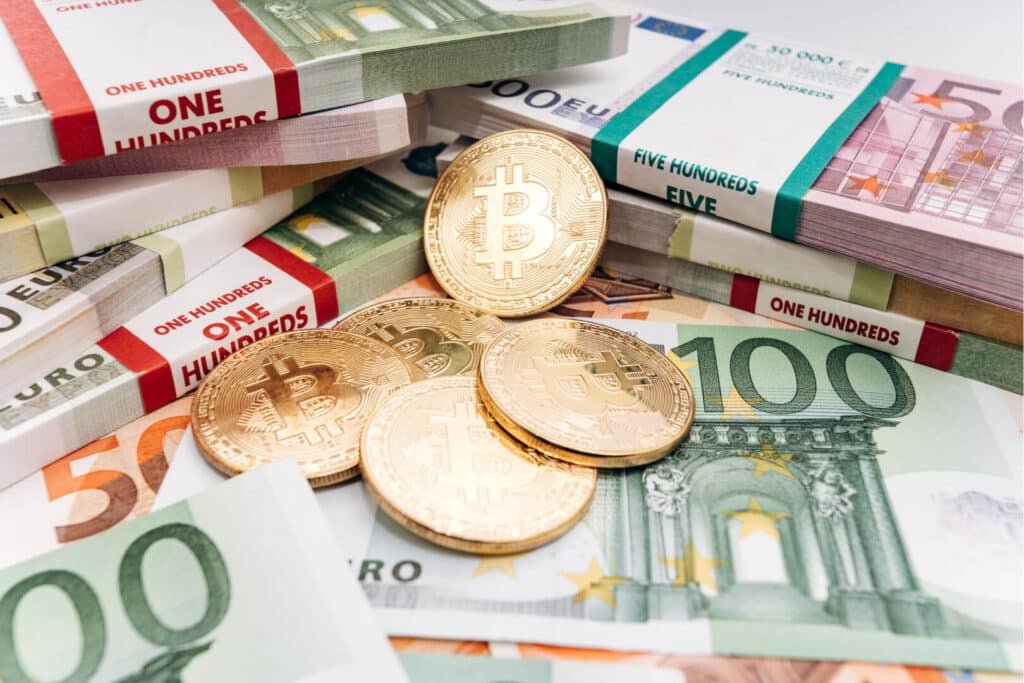 Physical cryptocurrency coins resting on paper money bills